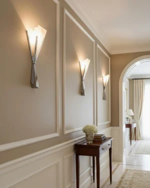 Chrome and white alabaster wall sconce installed in residential hallway with warm neutral wall trim, eye-level perspective