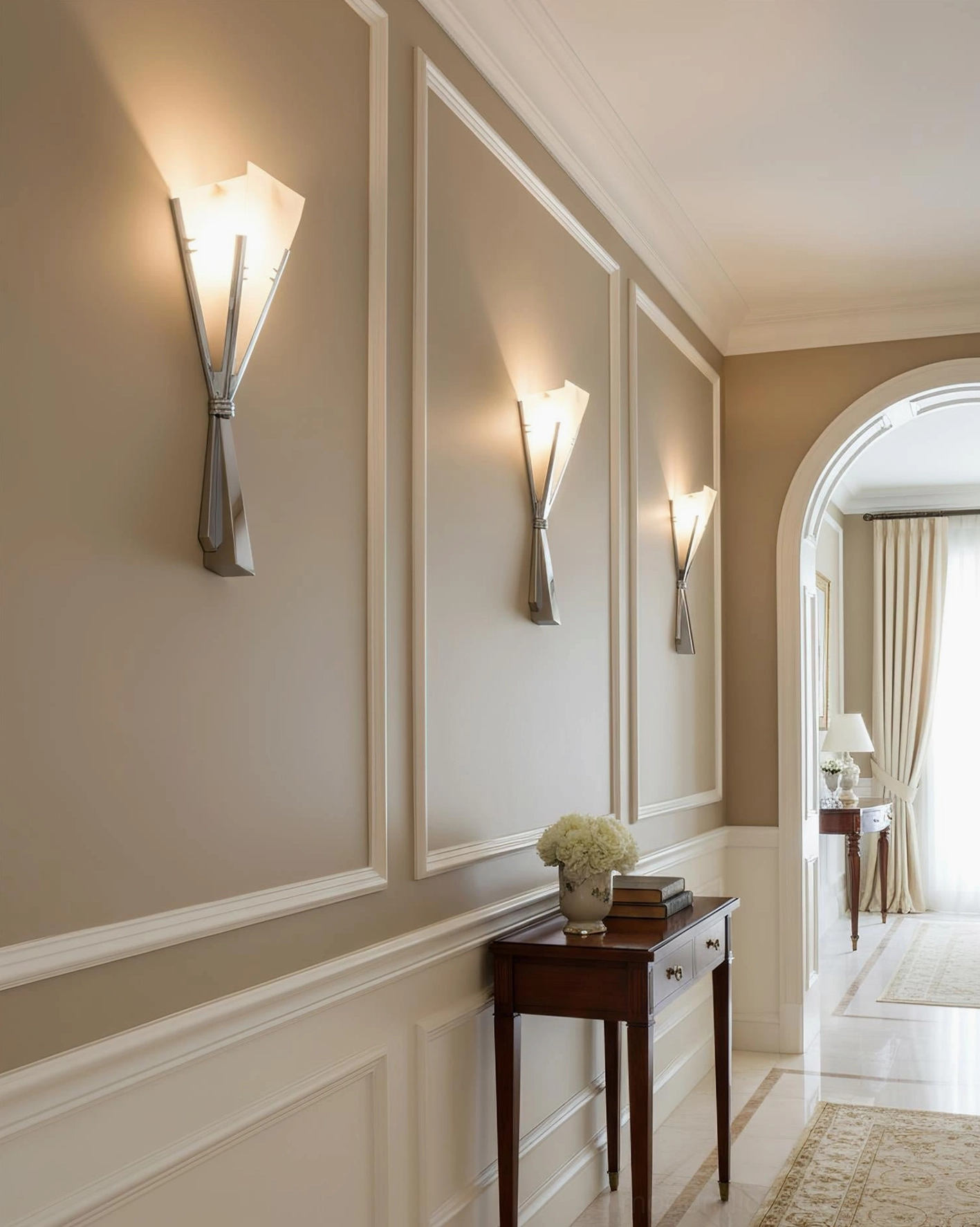 Chrome and white alabaster wall sconce installed in residential hallway with warm neutral wall trim, eye-level perspective