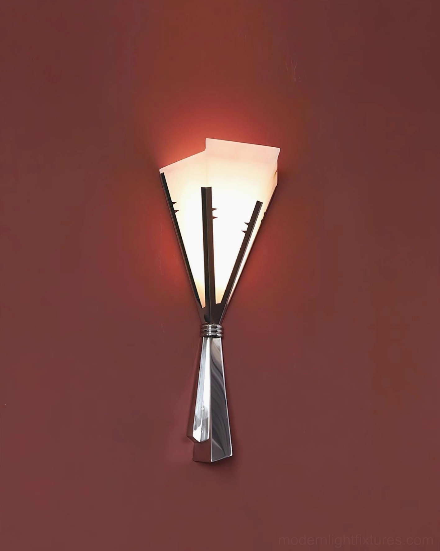 Art Deco geometric wall sconce emphasizing folded metal planes creating dramatic shadow and light interplay on wall surface
