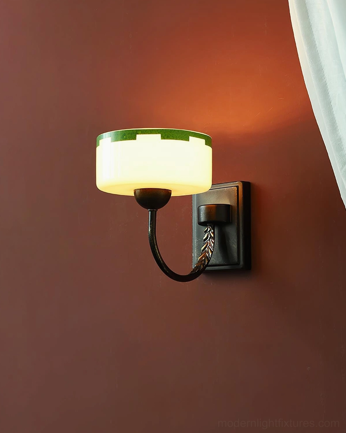 Vintage Art Deco wall sconce with milky glass shade and geometric green border, bronze arm fixture