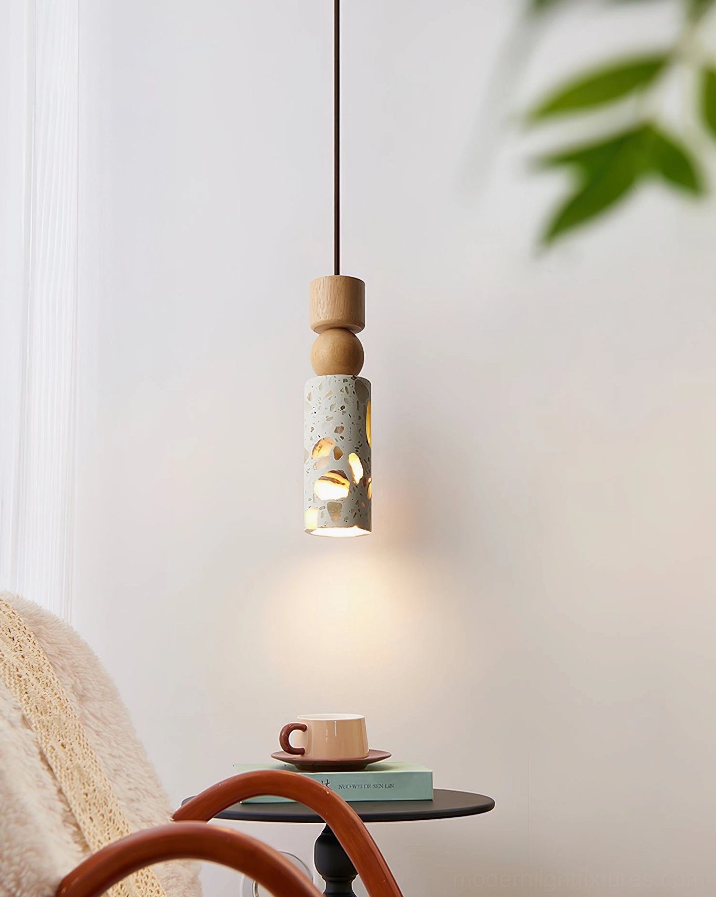 Artena pendant light in living room lounge corner creating warm ambient glow through geometric cut-outs