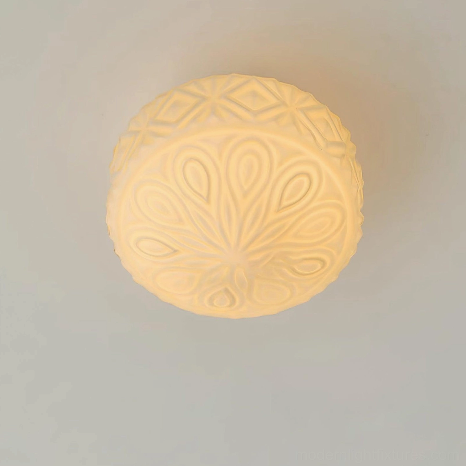 Carved glass ceiling light fixture showcasing artistic embossed design and warm vintage-inspired illumination qualities