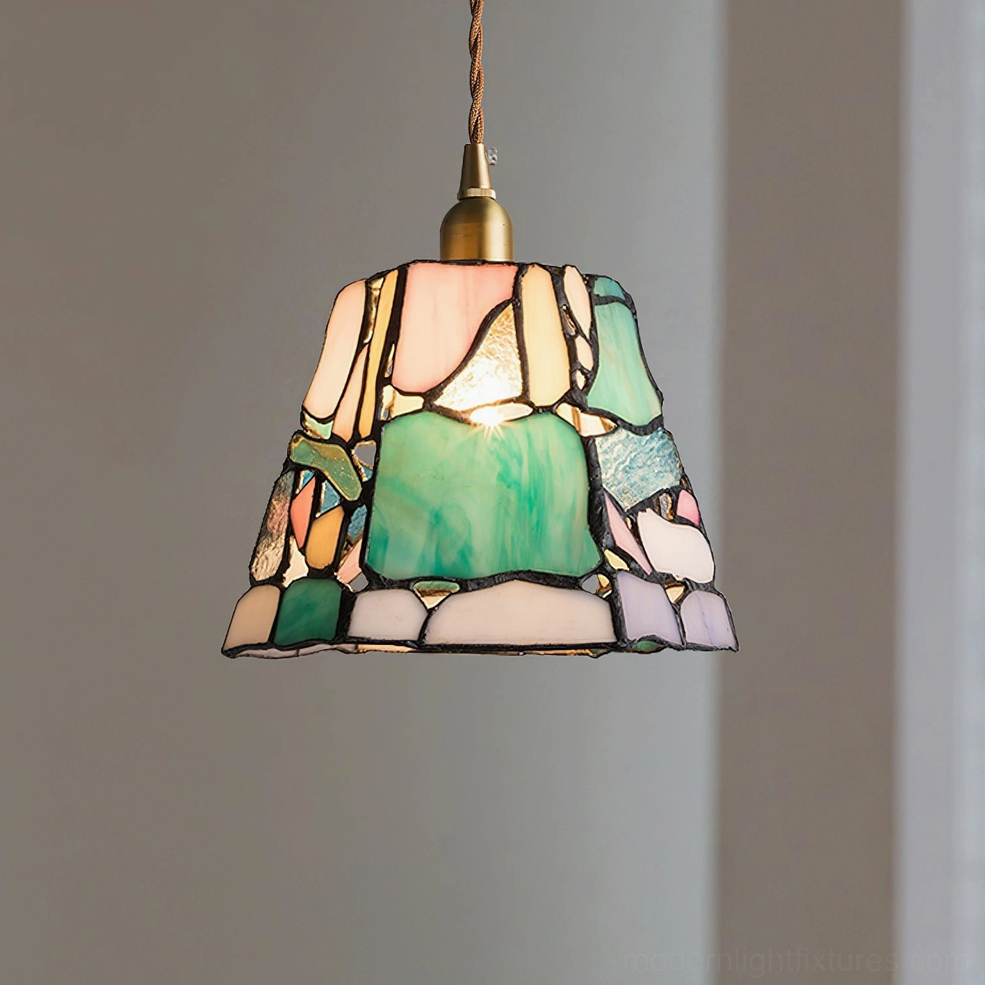 Artistic stained glass pendant fixture creating warm prismatic light glow and shadow patterns on walls