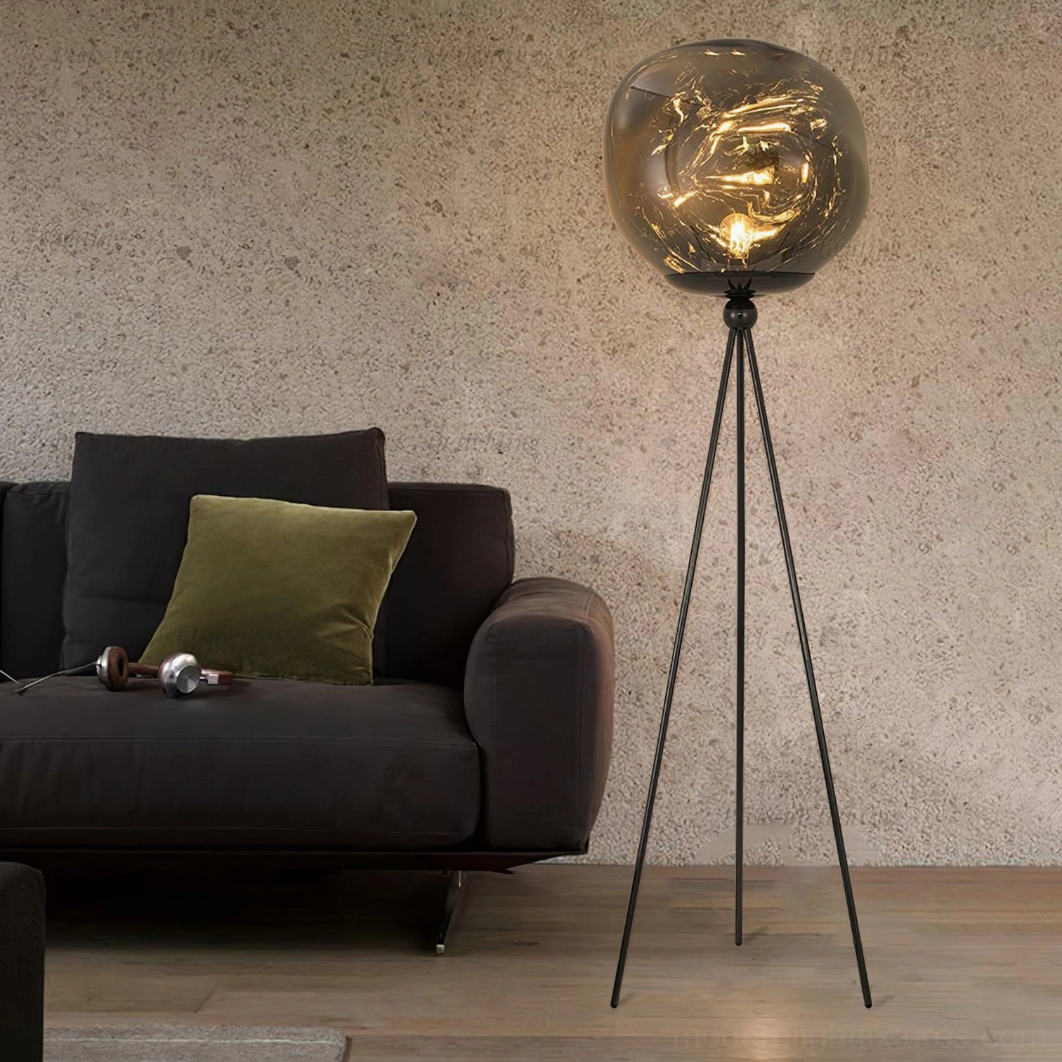 Artistic tripod floor lamp with black frame and decorative molten glass shade in modern interior space