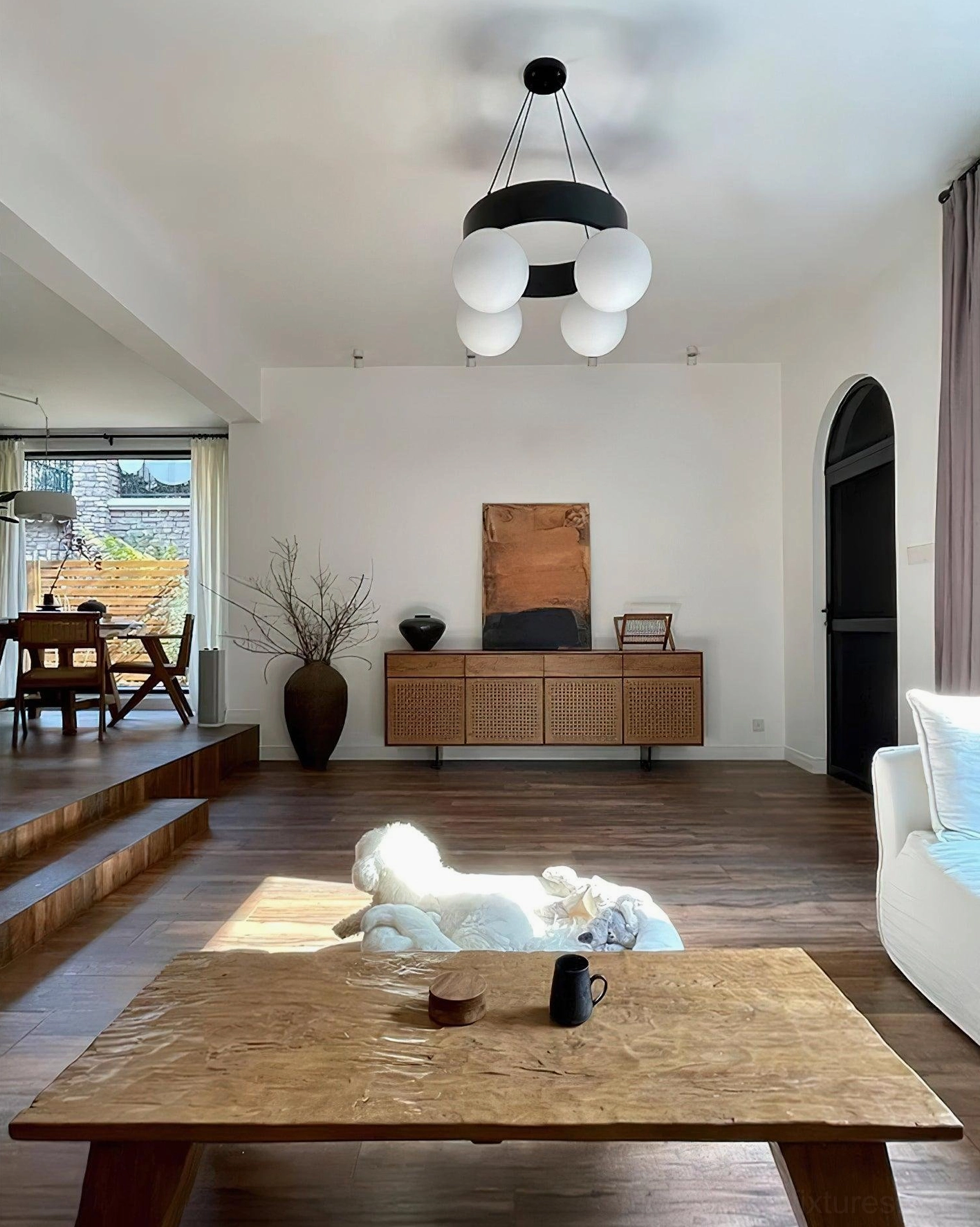 Black metal ring globe pendant chandelier in contemporary warm-toned living room - high-angle view