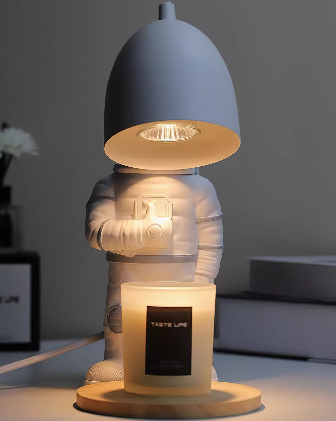 Modern astronaut table lamp low angle view with dark matte shade emitting warm light in home office