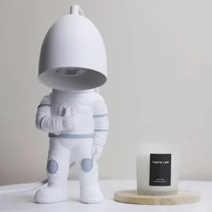 Astronaut candle warmer lamp close-up showing matte white finish with wooden candle tray on tabletop