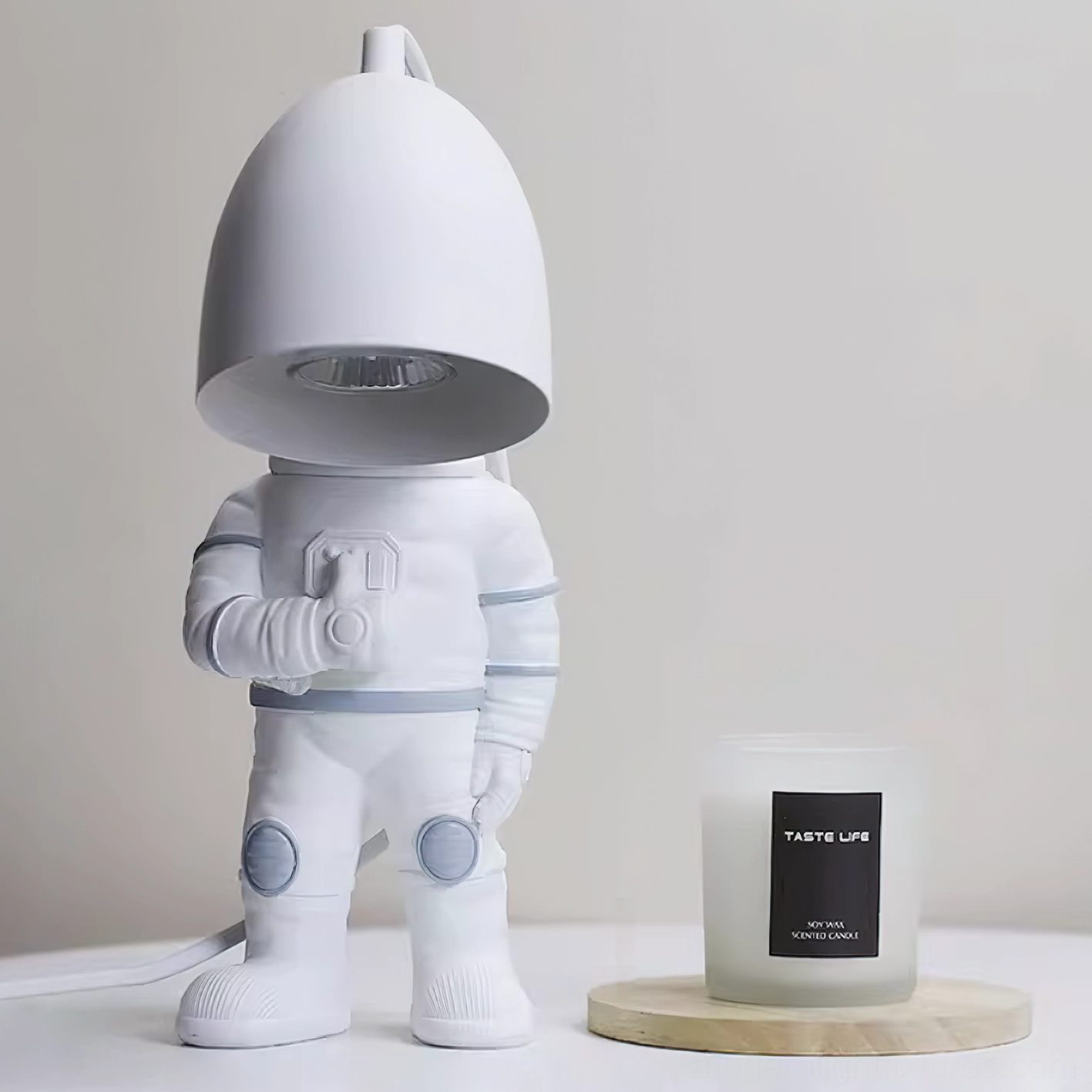 Astronaut candle warmer lamp close-up showing matte white finish with wooden candle tray on tabletop