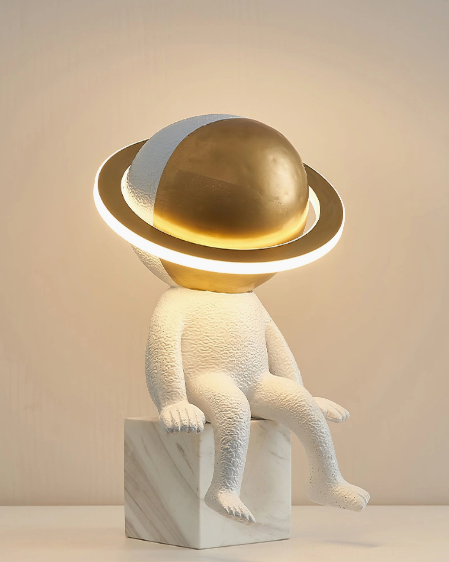 Astronaut Halo table lamp fully illuminated with warm LED light on marble base in indoor shelf setting