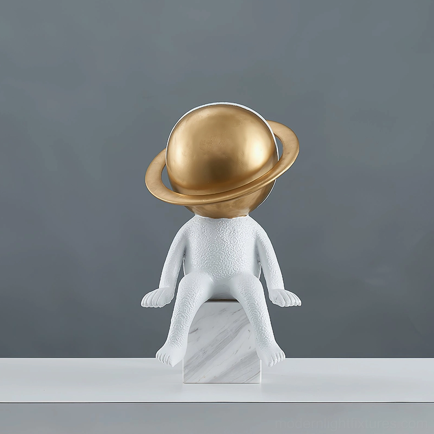 Astronaut table lamp showing textured white resin astronaut figure with illuminated golden planet halo