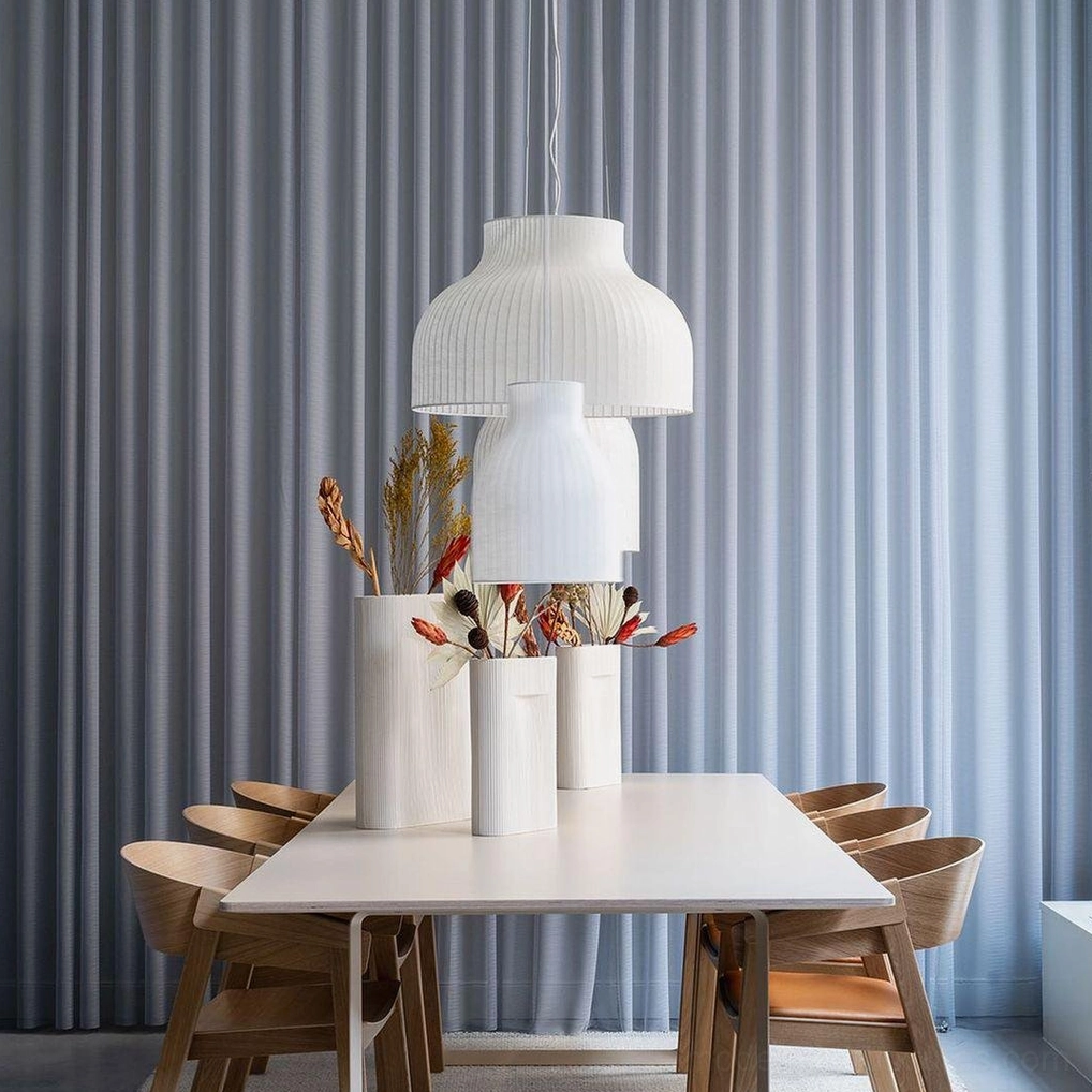 Modern white pendant light creating atmospheric lighting in minimalist interior design setting