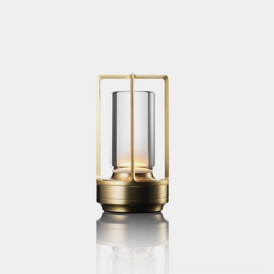 Aura Gleam cordless LED table lamp with gold aluminum frame and clear glass shade, front view minimalist studio display