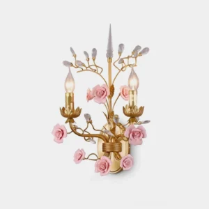 Aureflora floral wall sconce front view with dual candle-style lights, copper gold frame, pink ceramic roses and crystal accents on studio background