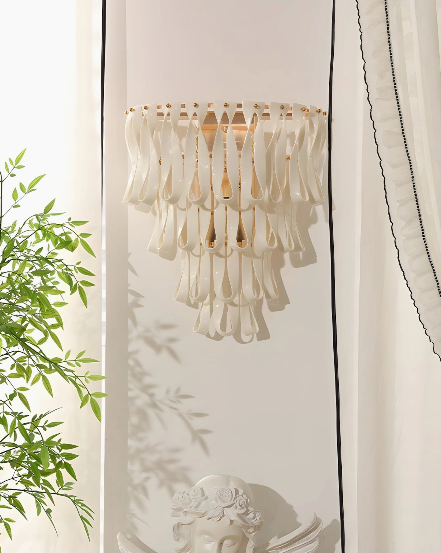 Cascading ceramic ribbon wall sconce creating soft sculptural light in cozy home corner with potted plant
