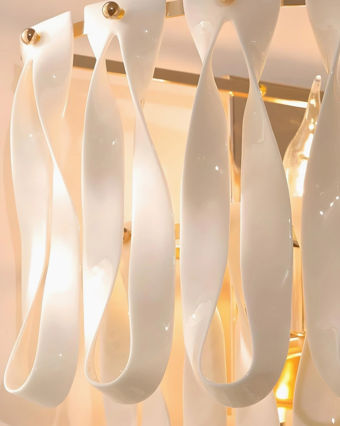 Avelisse wall sconce close-up detail showing hand-finished ceramic ribbon loops and gold hardware construction