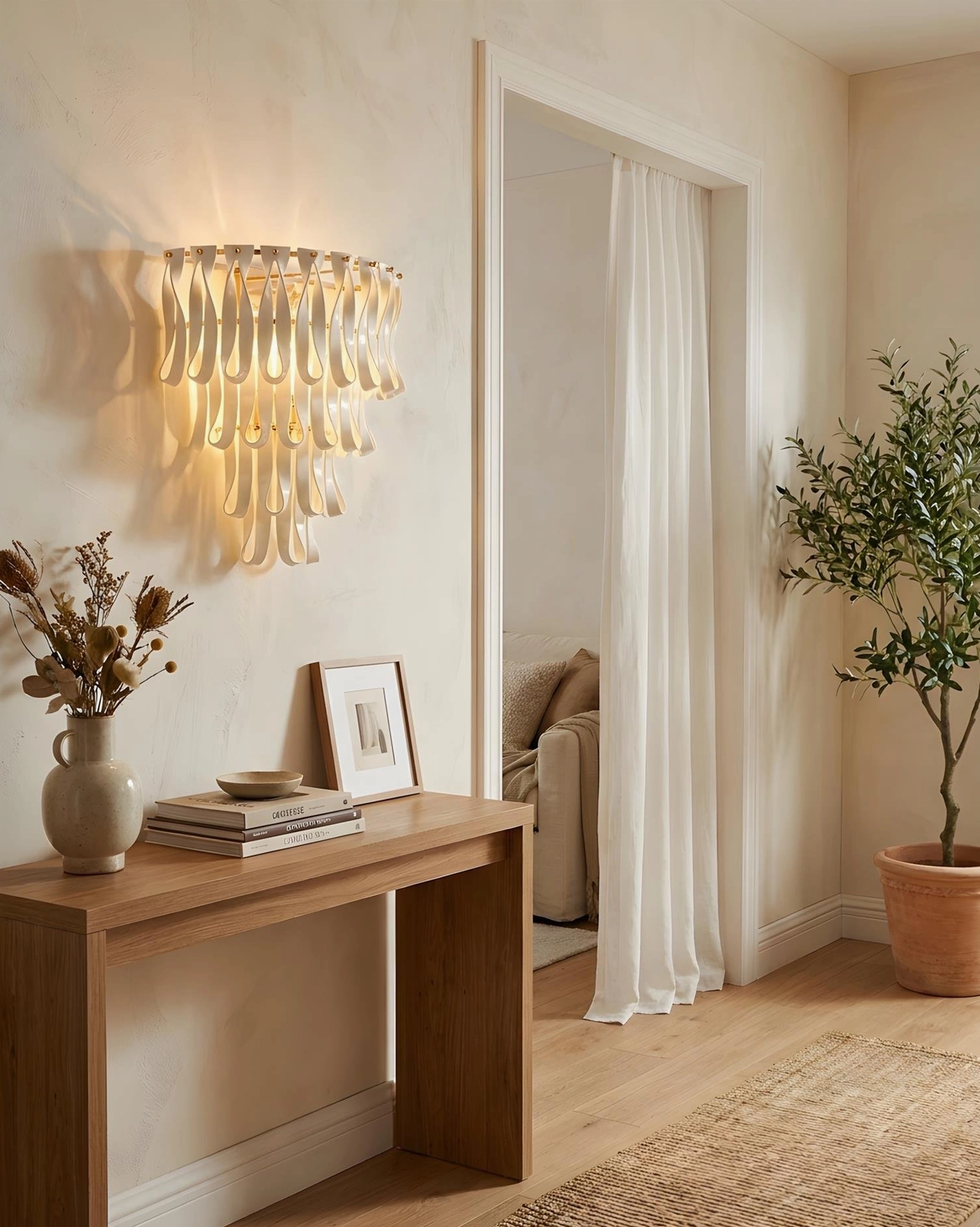 Contemporary ceramic ribbon wall sconce in hallway with framed artwork and neutral wood tone furnishings