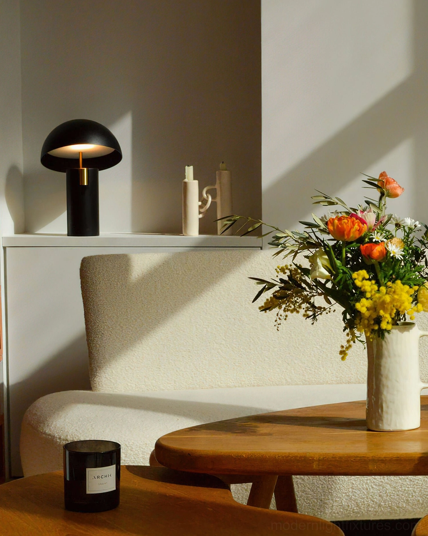 Black Avo mushroom LED table lamp placed on shelf in cozy modern living room interior design scene