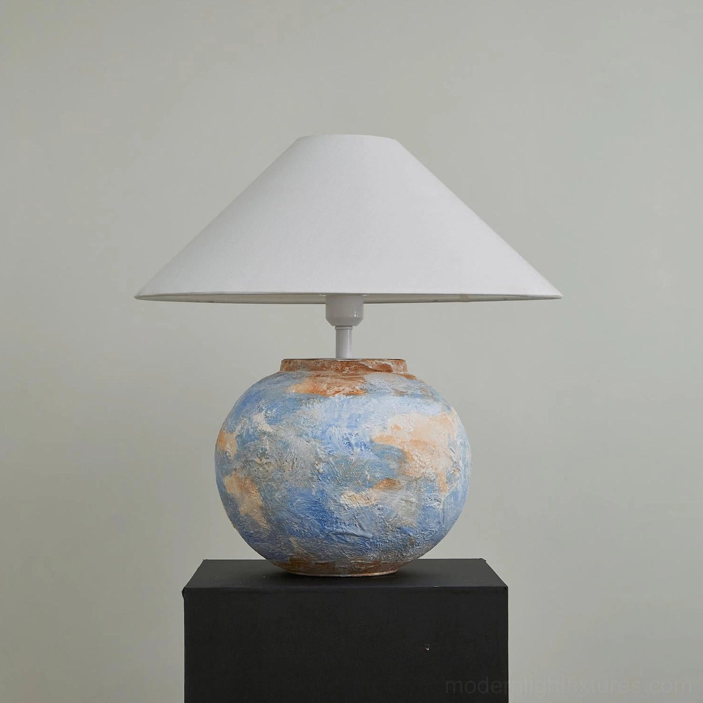 Bailey handcrafted ceramic table lamp with blue textured base and white shade on black pedestal