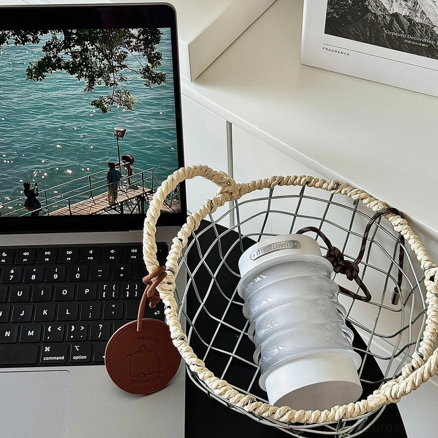 Balia rechargeable table lamp in home office setup, positioned in wire storage basket on desk with laptop and workspace accessories