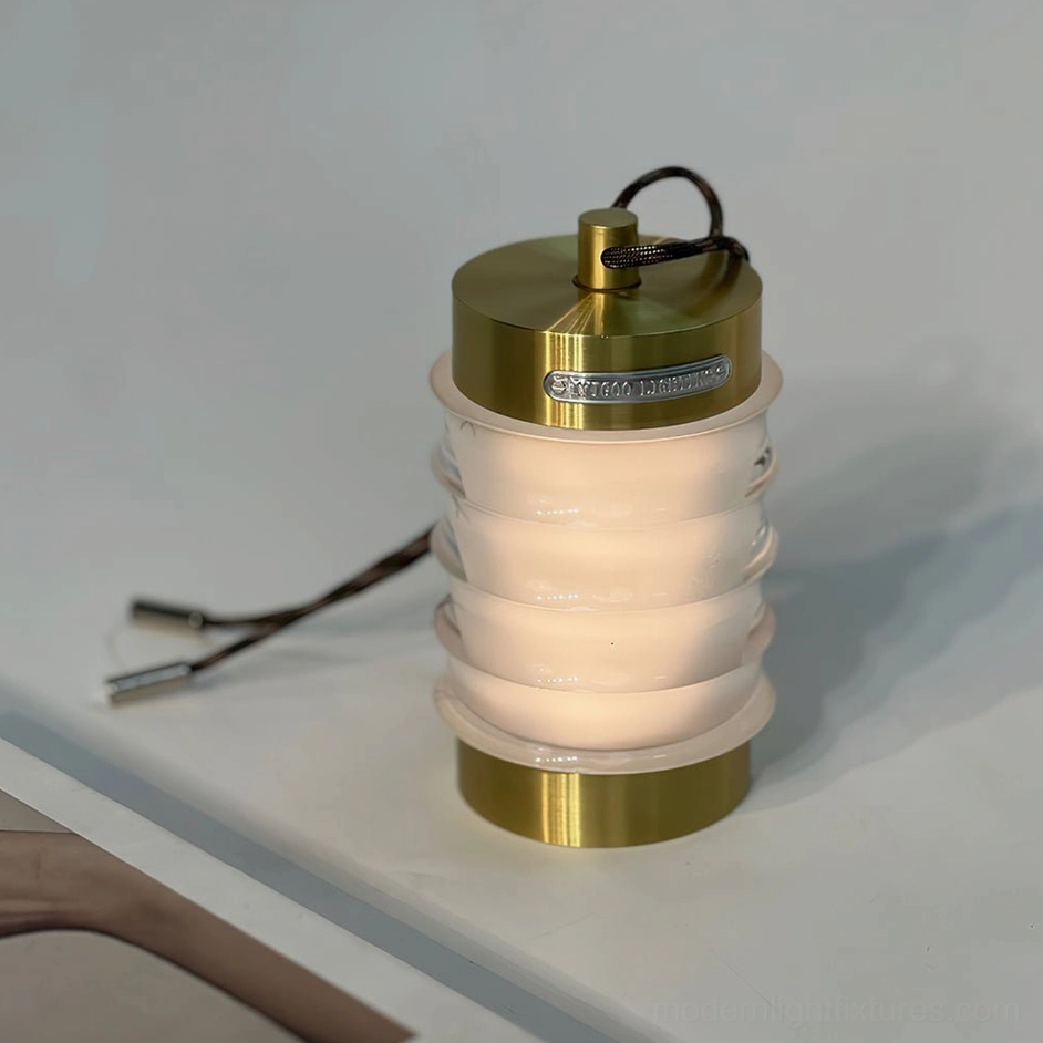 Silver Balia portable rechargeable table lamp with full brushed metal top and base, three-quarter side view on minimalist white desk