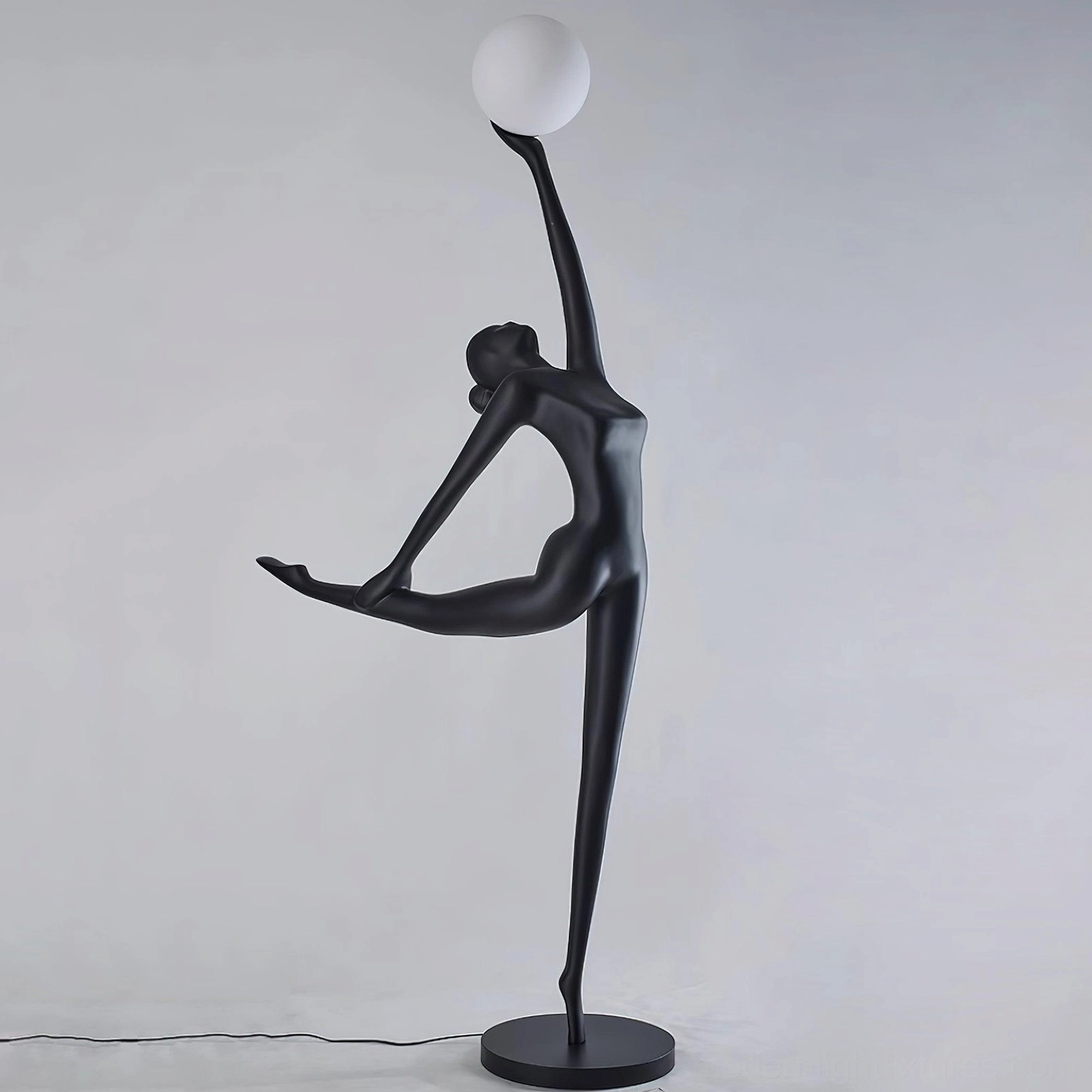 Elegant ballerina sculptural floor lamp showing matte black resin dancer form and white luminous orb