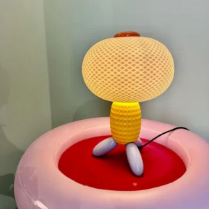 Yellow Balloons sculptural lamp glowing on pink round furniture with power cord