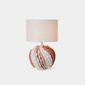 Balza ceramic table lamp with sculptural ruffled globe base in terracotta and white, cylindrical fabric shade on white studio background