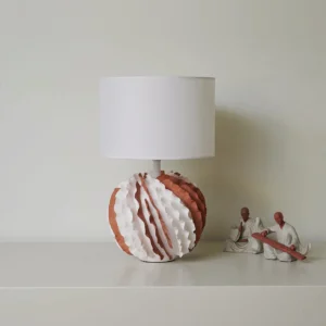 Balza decorative table lamp three-quarter view lit with ceramic ornaments, showing ruffled texture detail and fabric drum shade