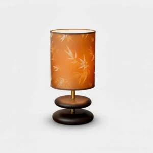 Bamboo leaf table lamp with orange botanical shade and dark wood base with gold accents, studio front view