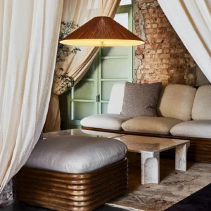Pleated bamboo pendant lamp hanging in vintage bohemian living room interior, warm brown shade with rustic decor