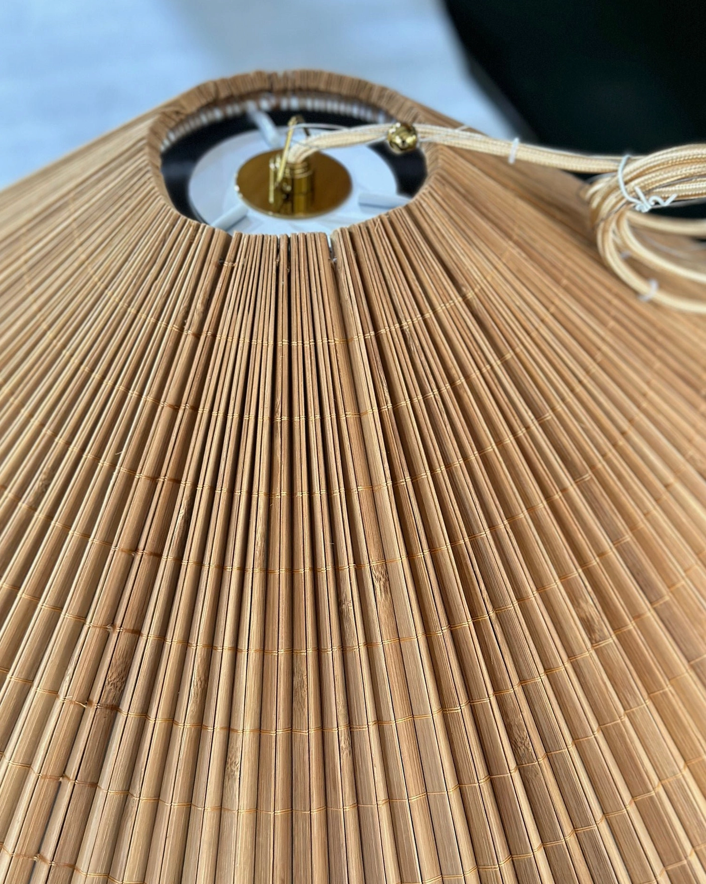 Warm glowing bamboo conical pendant shade showing color richness and natural material patina