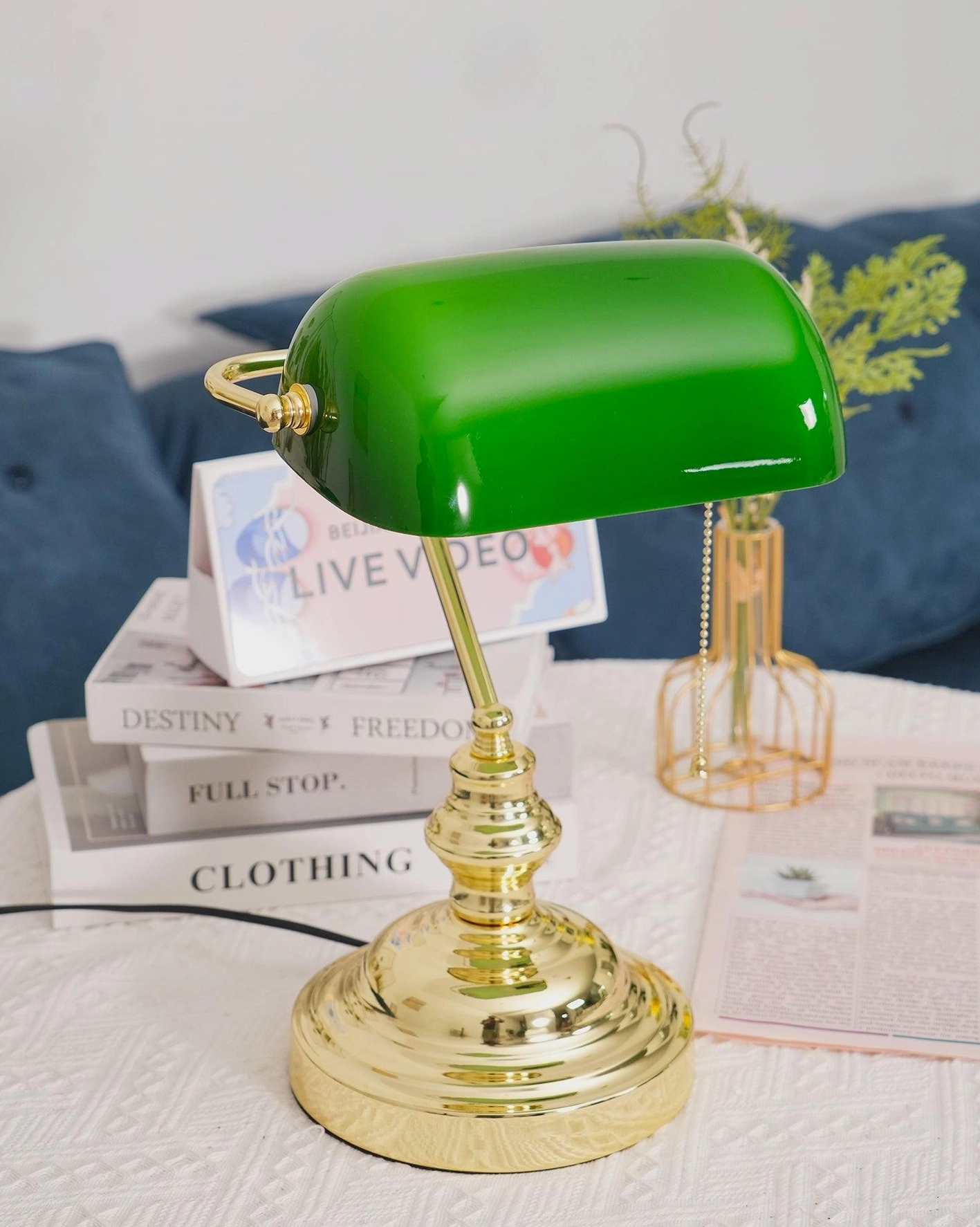 Banker table lamp green glass shade polished gold base on stacked books display