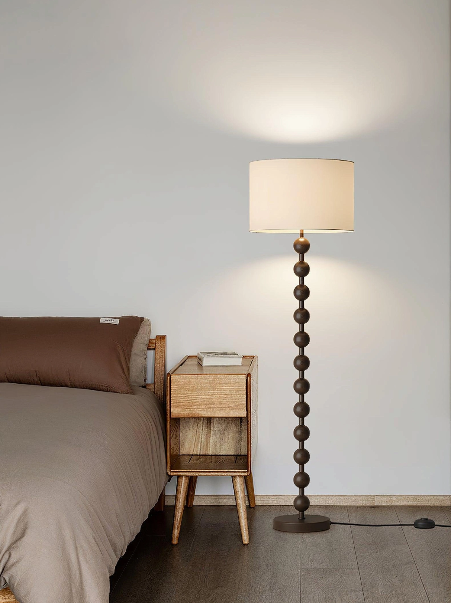 Walnut barbell floor lamp creating warm ambient glow in bedroom