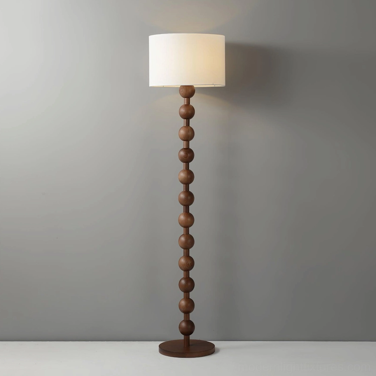 Medium brown wood barbell floor lamp with cream shade on grey background detail