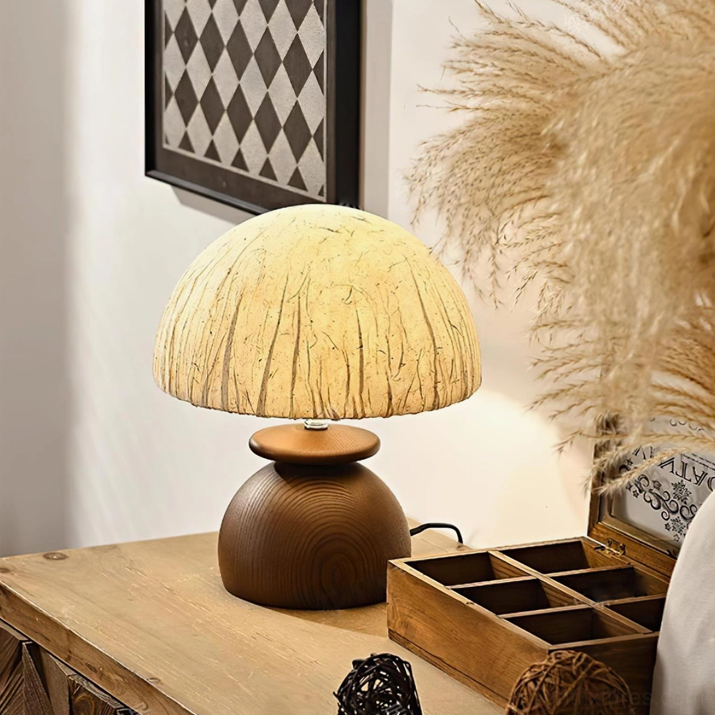 Glowing Basira lamp on dresser with checkered wall art and pampas grass, cozy minimalist bedroom setup