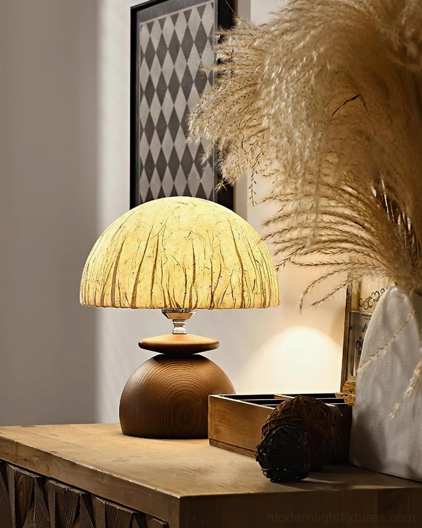 Right-angle view of glowing Basira mushroom lamp creating warm ambient light with pampas grass and wall art