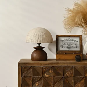 Modern organic table lamp displayed on wooden dresser with boho decor and pampas grass, three-quarter front angle