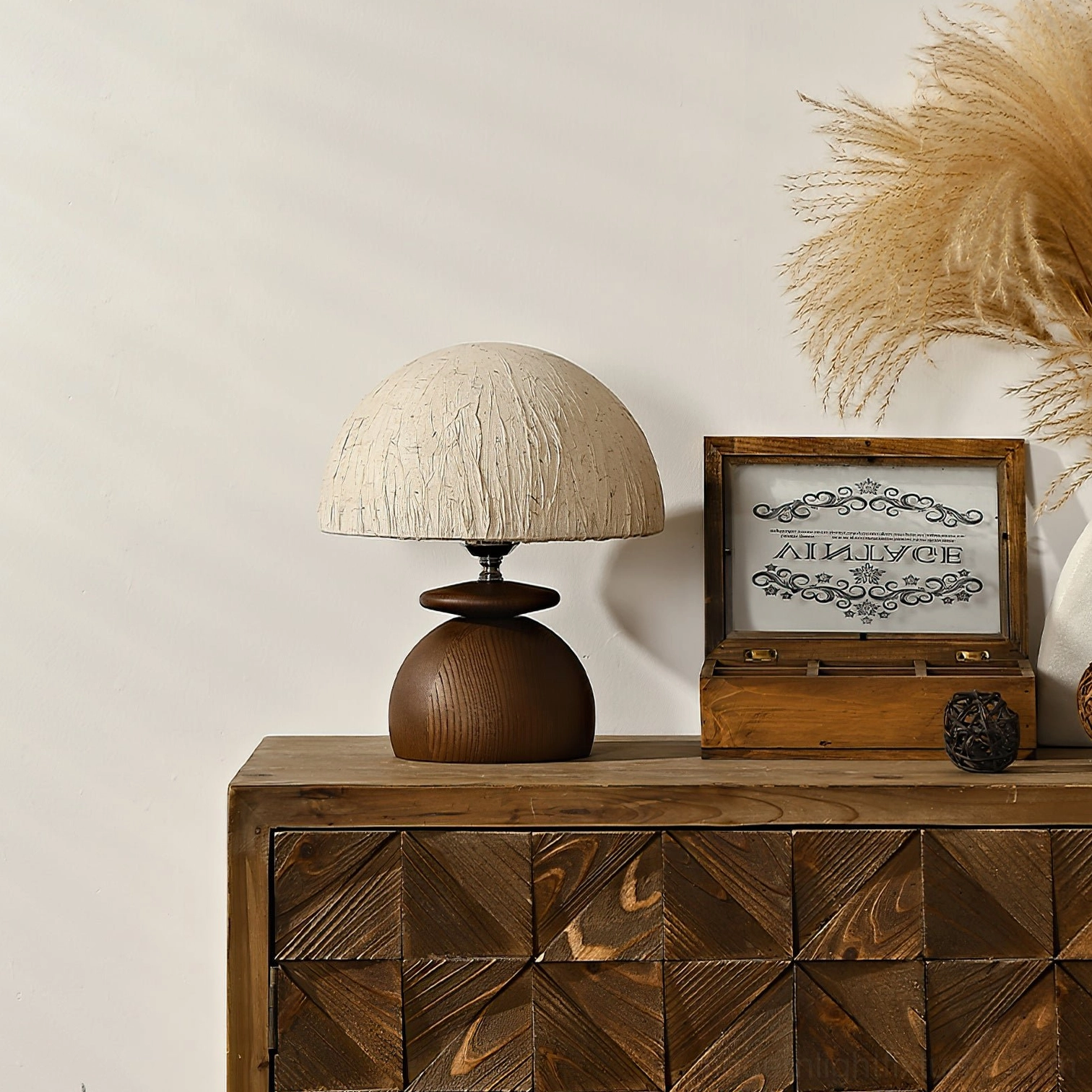 Modern organic table lamp displayed on wooden dresser with boho decor and pampas grass, three-quarter front angle