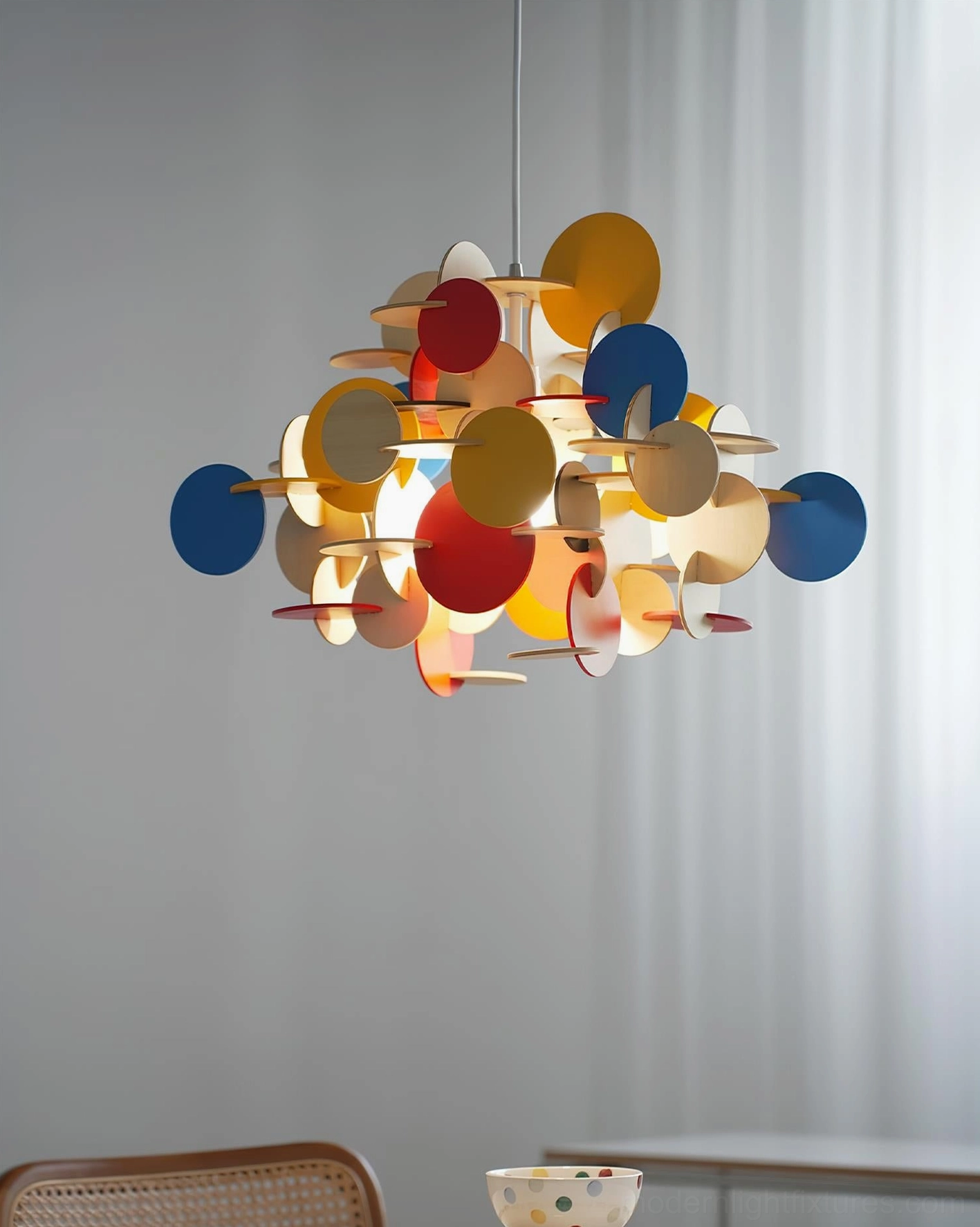 Bau pendant light three-quarter view showcasing sculptural wooden disc composition and color variety