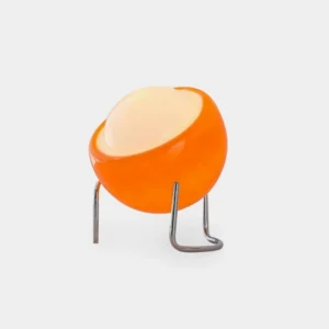 Bauhaus dome table lamp with tilted orange glass shade and chrome curved tripod stand, studio white background view