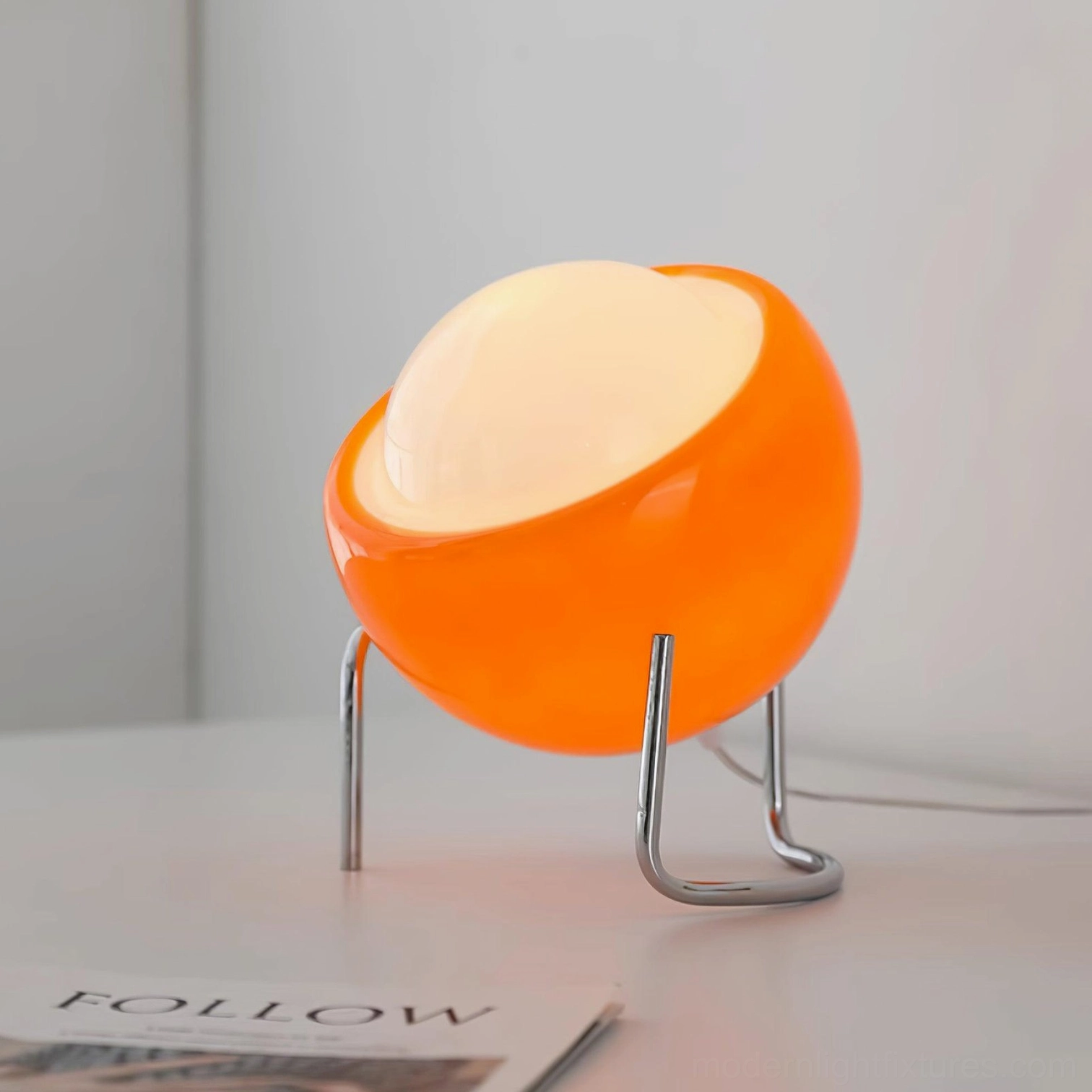 Mid-century modern dome table lamp with warm ambient glow, tilted glass shade on chrome metal stand, desktop setting