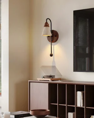 Beacon wall sconce installed in residential media cabinet area with warm ambient lighting