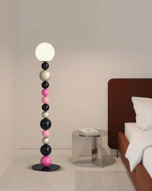 Multicolored bead floor lamp in bedroom setting, styled with brown bed and side table, contemporary interior lighting