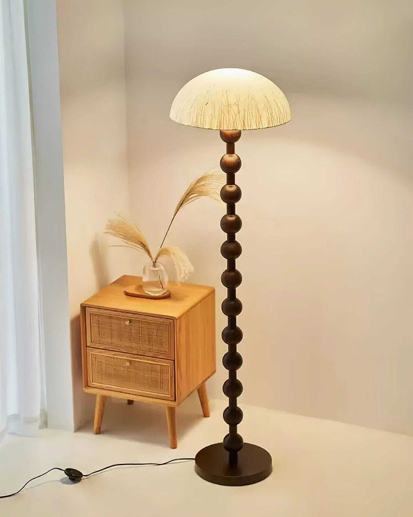 Walnut beaded floor lamp beside rattan nightstand in modern bedroom corner