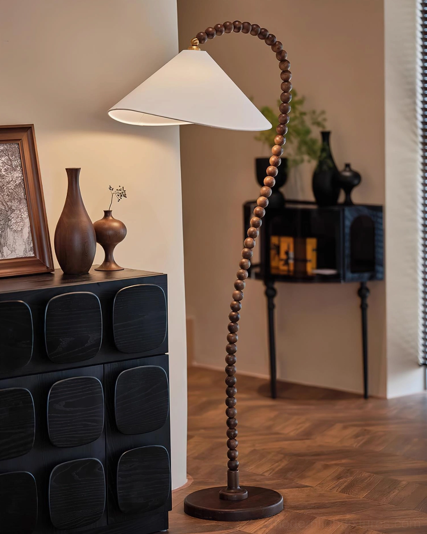 Wooden beaded floor lamp accent lighting in living room with dark cabinet and herringbone floor