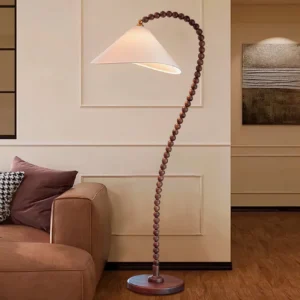 Modern wooden bead floor lamp in living room setting with brown leather sofa and warm decor