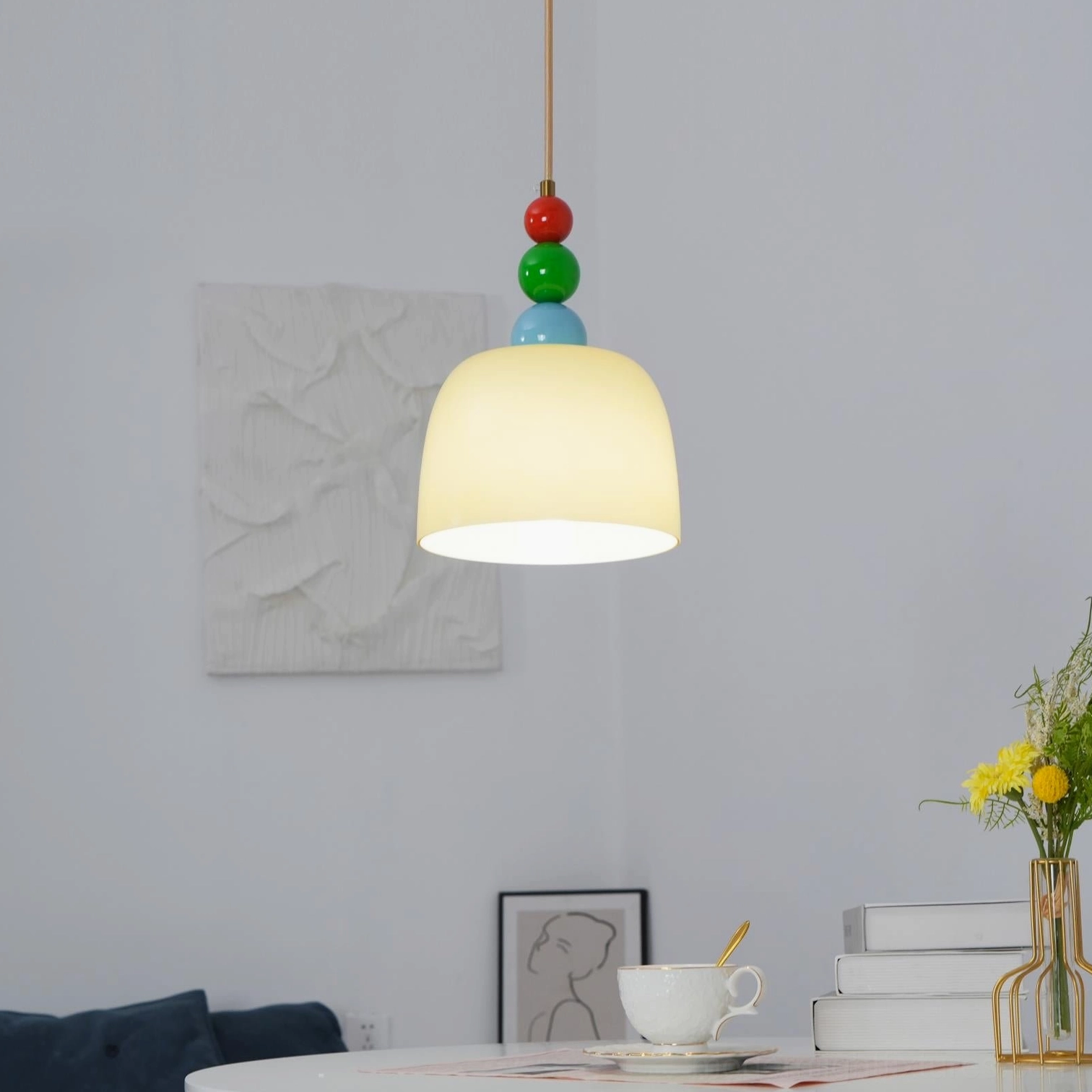 Playful colored bead pendant lamp above dining table creating warm cozy atmosphere