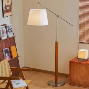 Beamline modern floor lamp in retro residential study, three-quarter interior view showing walnut wood and beige fabric shade