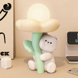 Bear-shaped table lamp in bedroom setting with warm ambient lighting, nightlight effect on bedside table with wall art and wireless charger