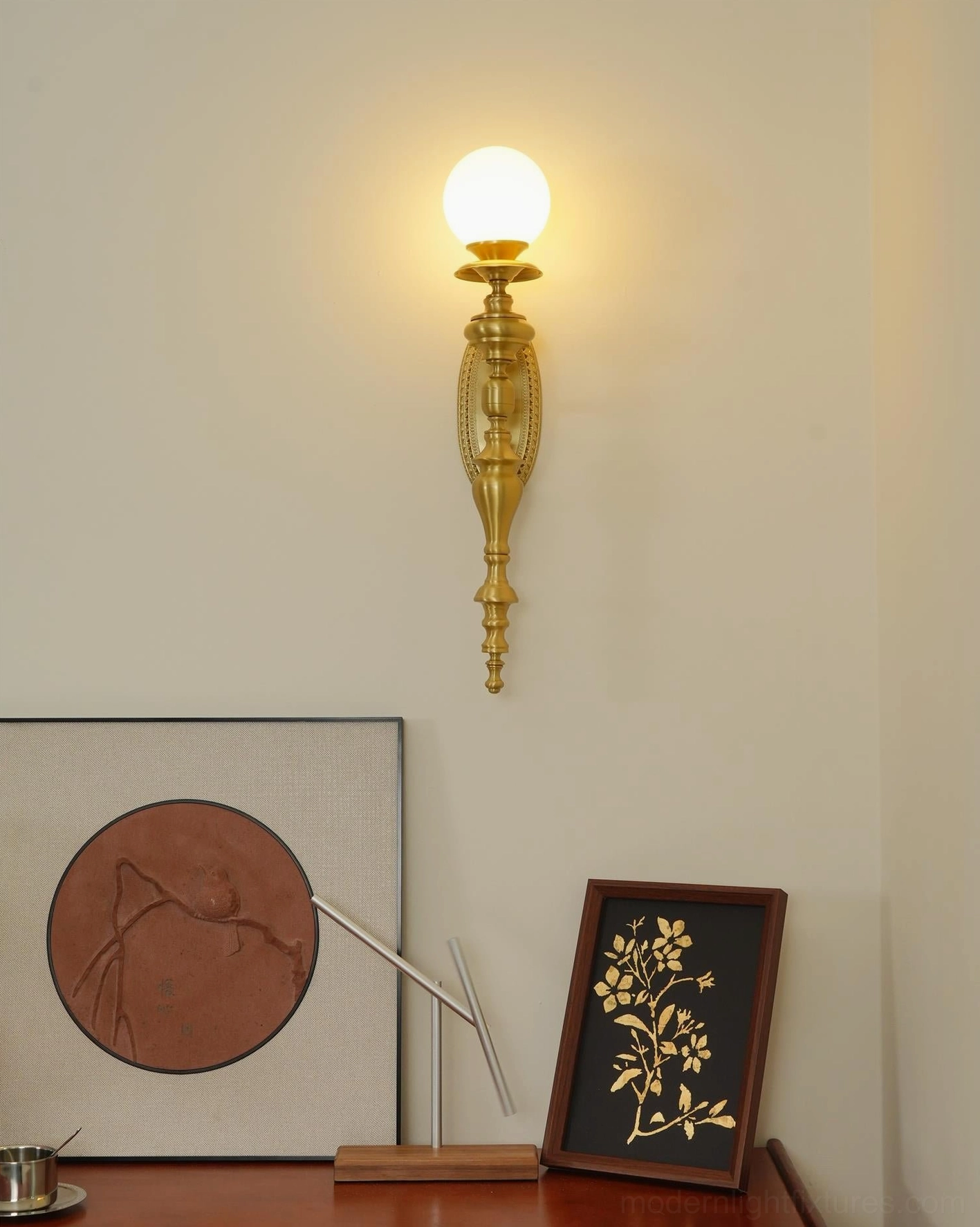 Vintage brass wall sconce with frosted globe shade in mid-century modern interior setting
